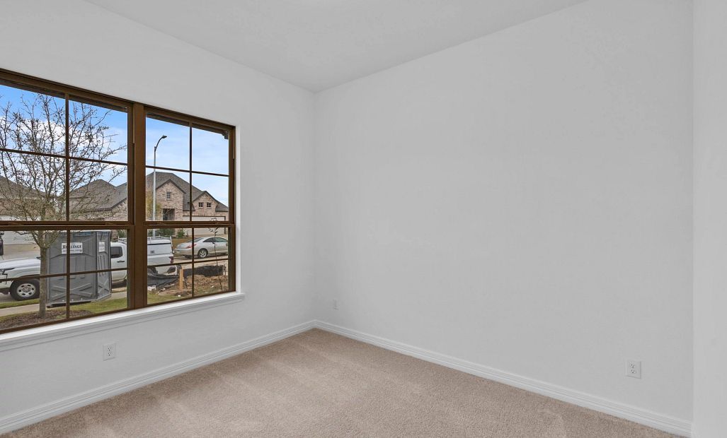 With two windows overlooking the front of the home, this secondary bedroom offers a light-filled