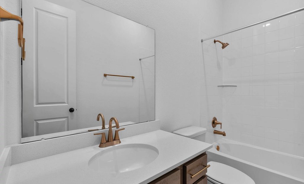 Stylish secondary bath featuring the AW Collection Laguna with stained cabinetry and light