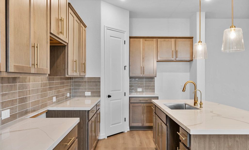 A chef’s dream kitchen with a central island, spacious walk-in pantry, and open connection to the