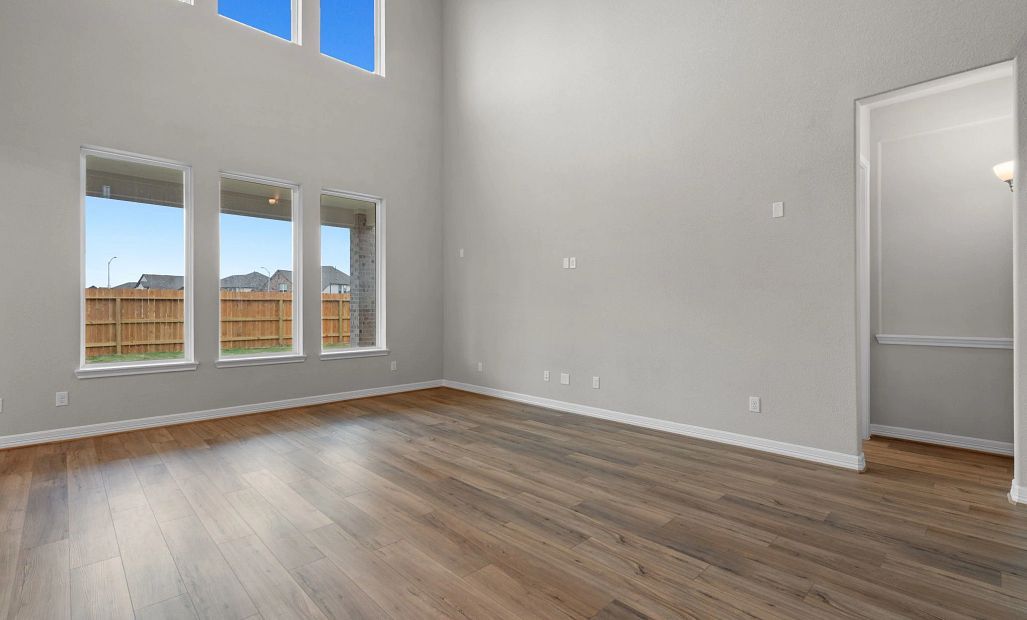 Spacious two-story family room with large windows, filling the space with natural light and an open,
