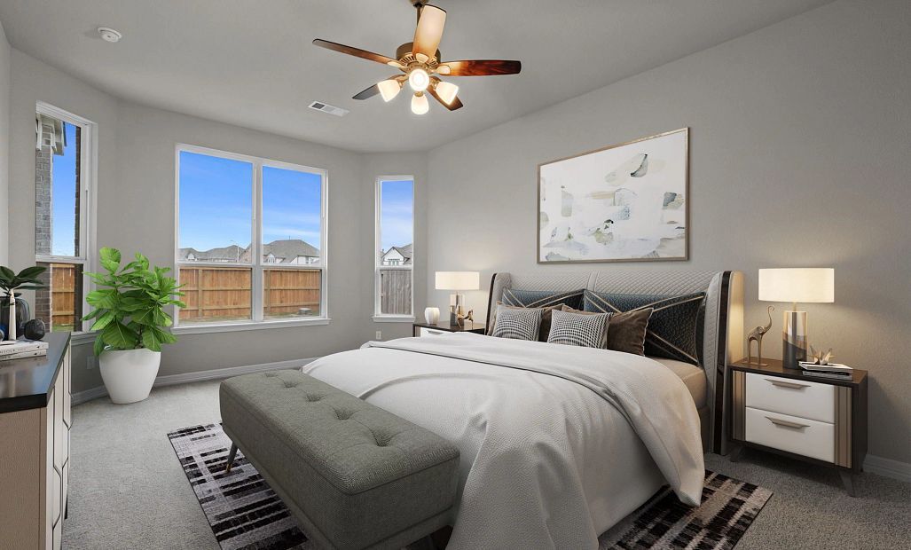 Luxurious primary suite with plush carpet, tray ceilings, and large bay windows—your perfect place