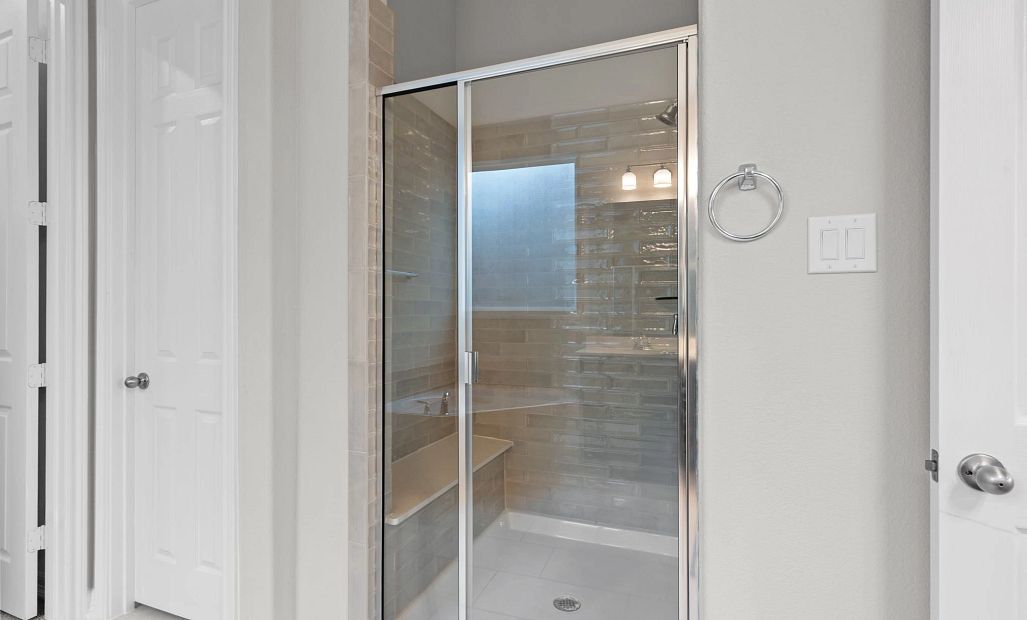 Spacious walk-in shower with beautiful tile surround and built-in bench—perfect for a spa-like