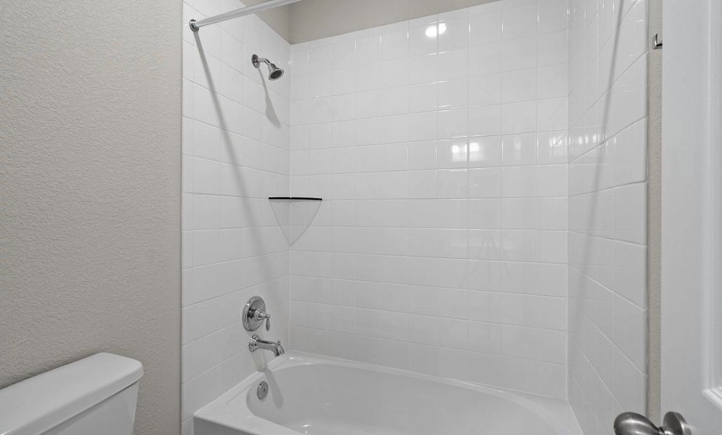 Bright and functional Jack and Jill bath with a privacy door separating the shower/tub area.