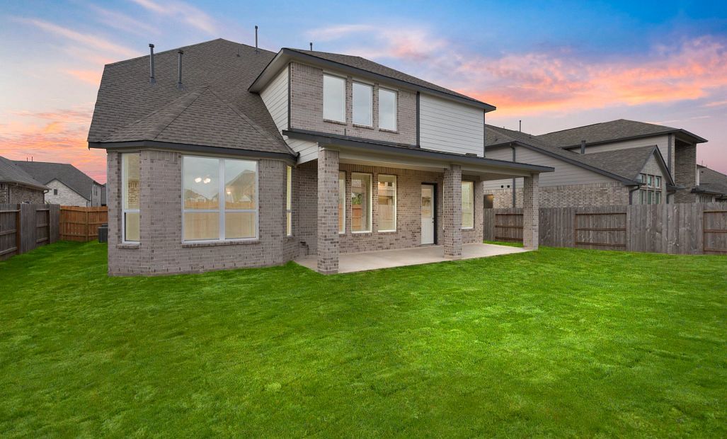 Enjoy outdoor entertaining in this backyard featuring a covered patio and plenty of space to gather.