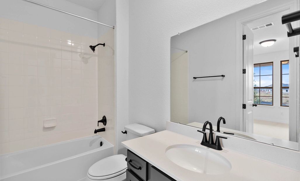 Stylish secondary bath featuring the AW Collection Rosemary with sage green cabinetry and light