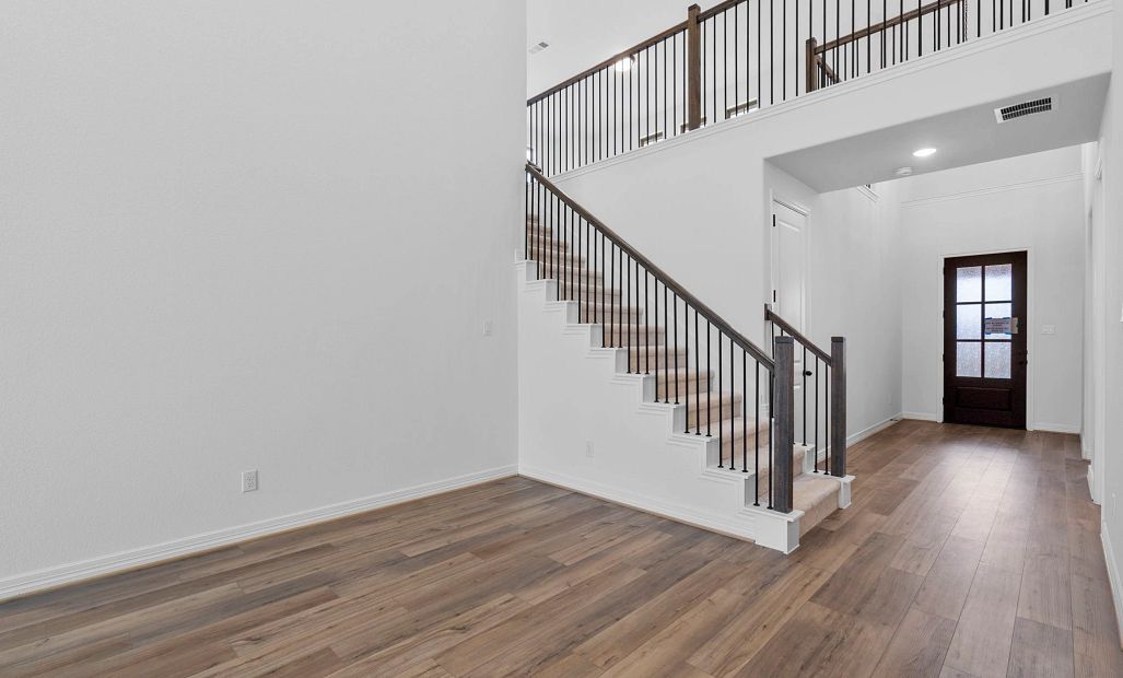 Additional view of the living room showcasing soaring two-story ceilings and beautiful iron