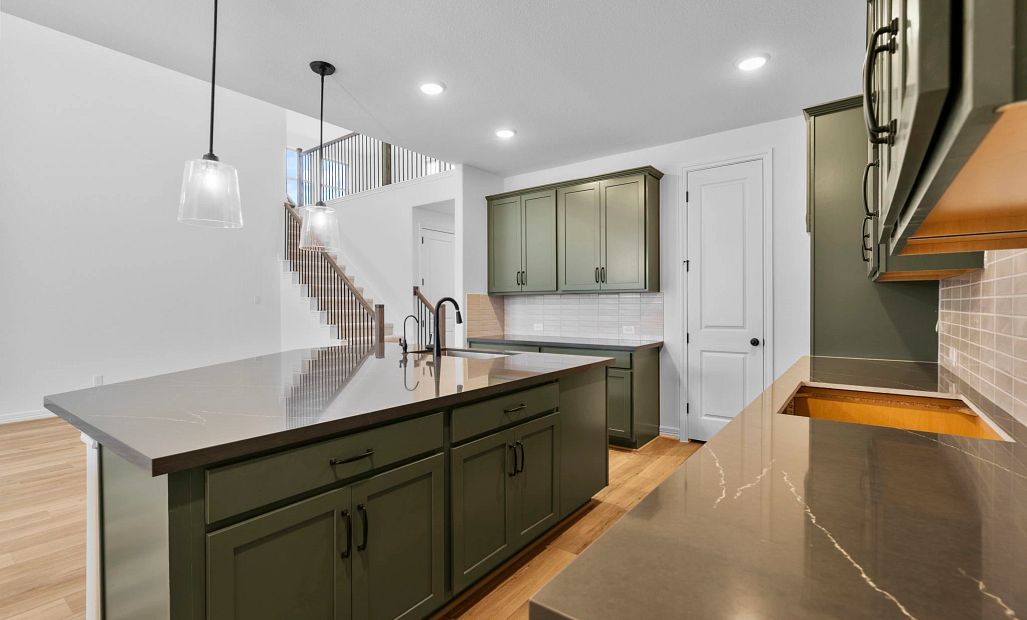 Kitchen with abundant cabinetry, generous countertop space, a walk-in pantry, and a center island