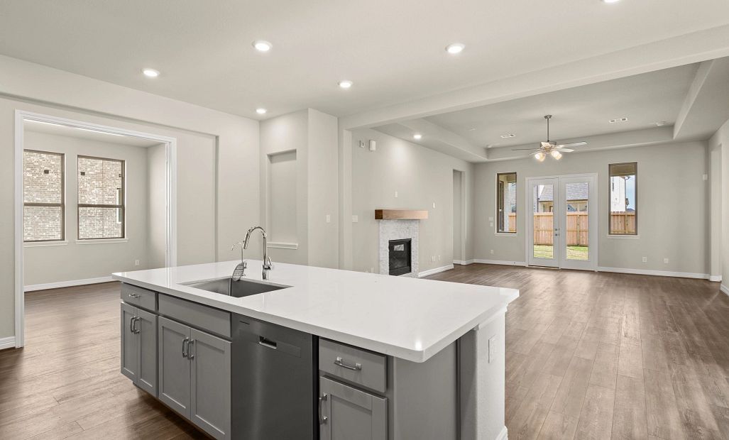 Kitchen open to family room. Note: Sample product photo - actual exterior and interior selections