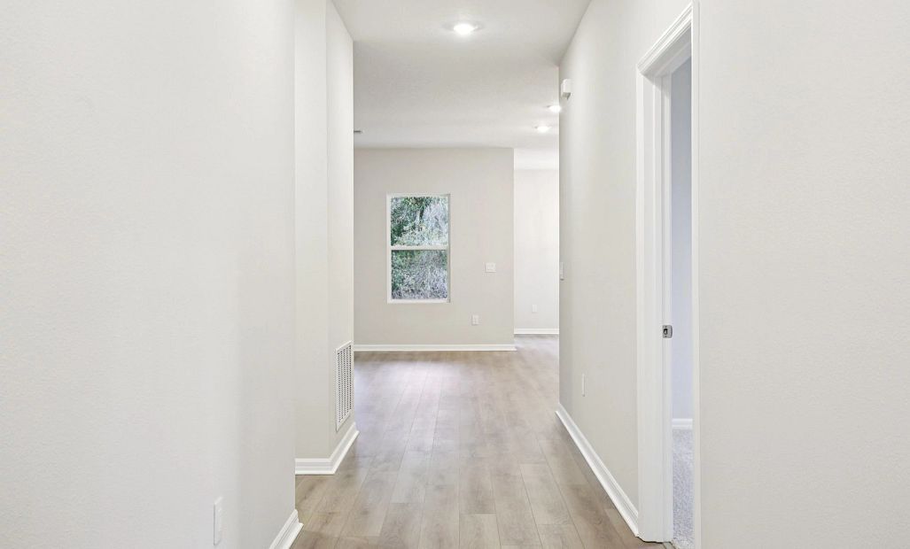 Hallway to additional secondary bedroom and living spaces