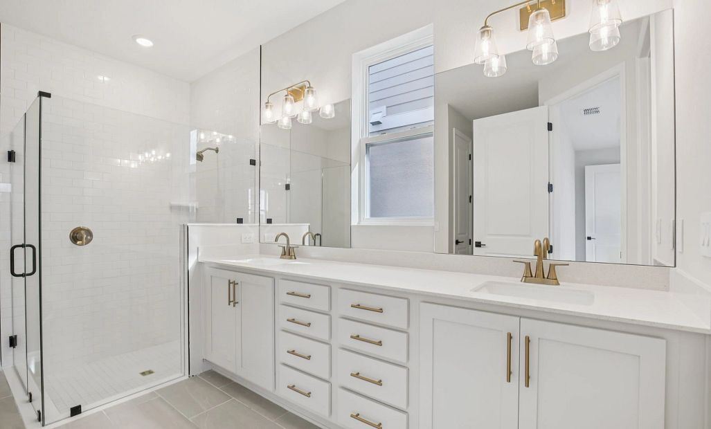 Beautiful primary bathroom with plenty of cabinet space, an added window and a large walk-in shower