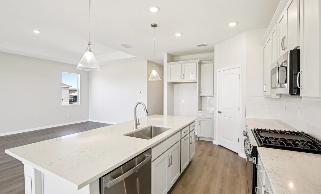 Large island with sink overlooking the family room featuring AW Collection® Milan