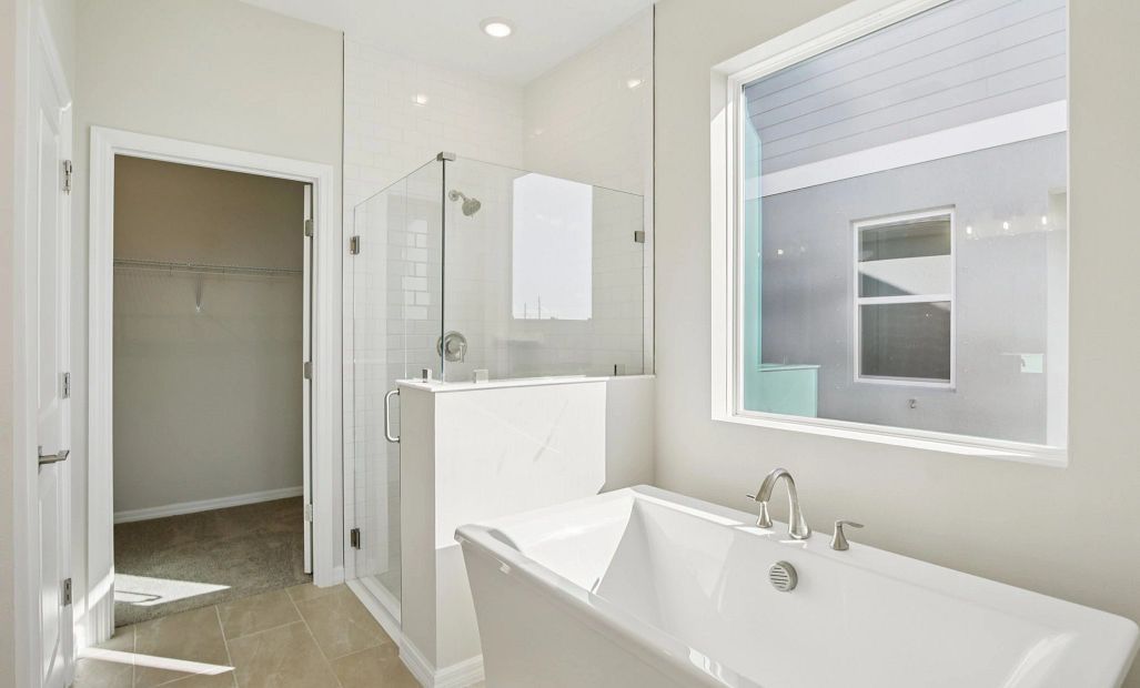 Primary bathroom with a free standing tub and a large frameless walk in shower