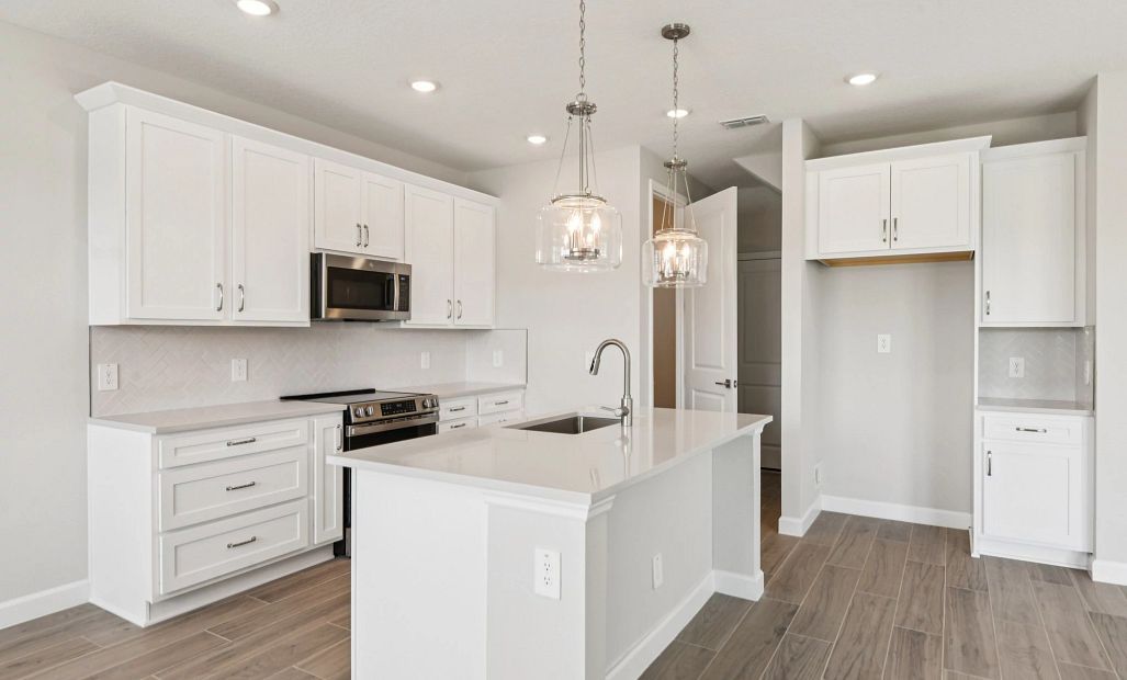 Additional cabinetry next to the refrigerator provides extra storage