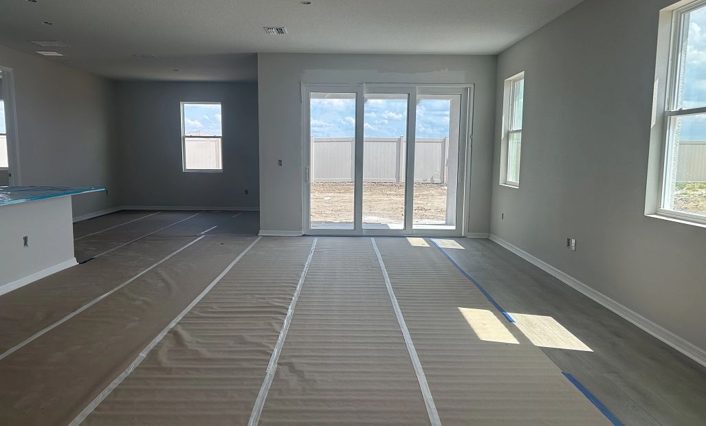 Spacious family room opens up into the kitchen and the large sliding glass door - under construction