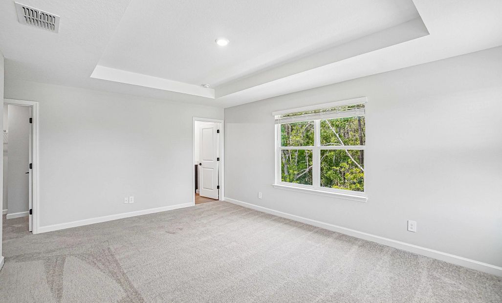 The primary bedroom has a beautiful treed view