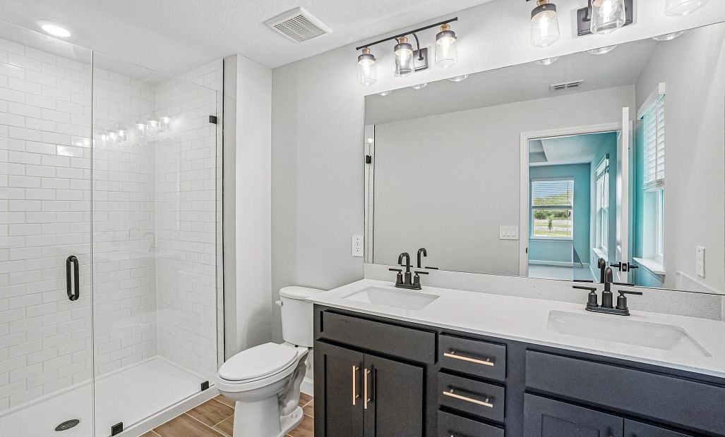 The primary bathroom features aspects of AW Collection® Noir and double sinks