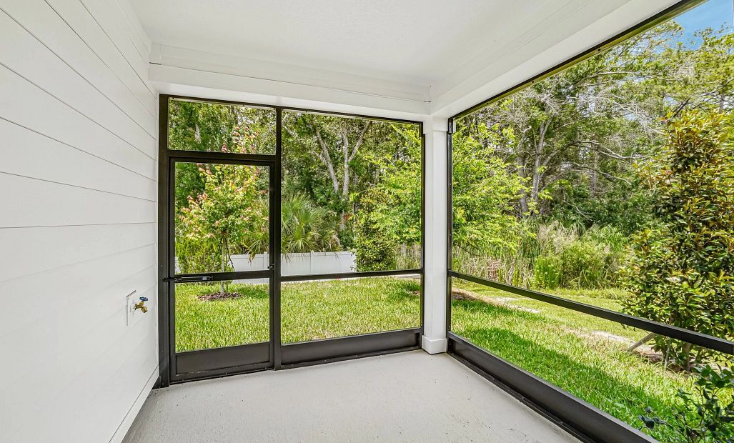 Spacious screened in back lanai with a tranquil and lush tree surrounding