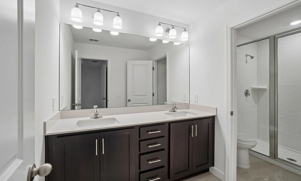 Primary bathroom features double sinks and a walk-in shower -  representative images