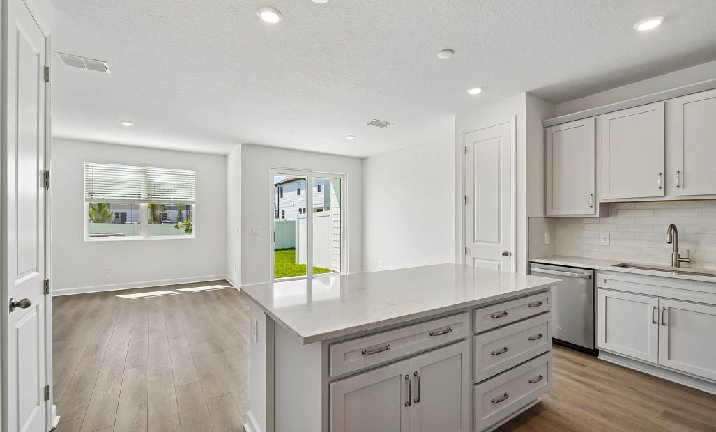 As you continue down the foyer you are welcomed into an open concept kitchen, dining and family room