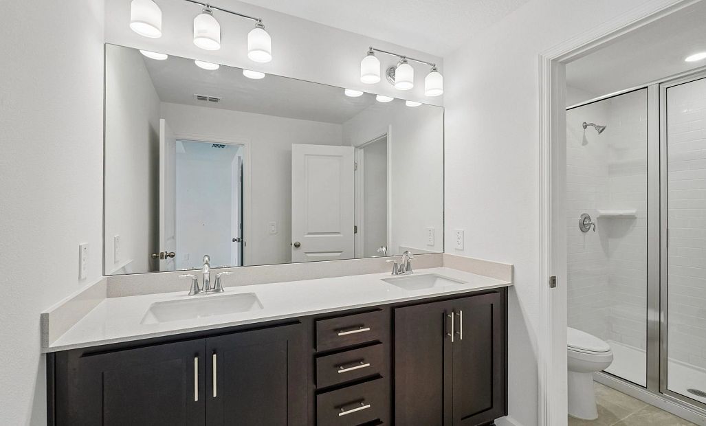 Primary bathroom featuring double sinks and a walk-in shower