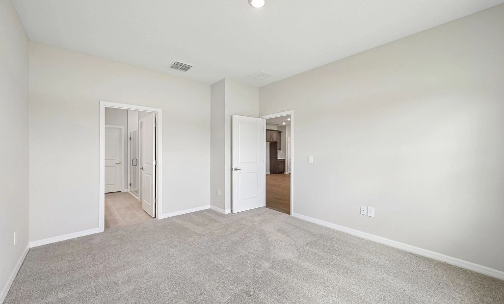 The spacious primary bedroom is located off the family room in the back of the home