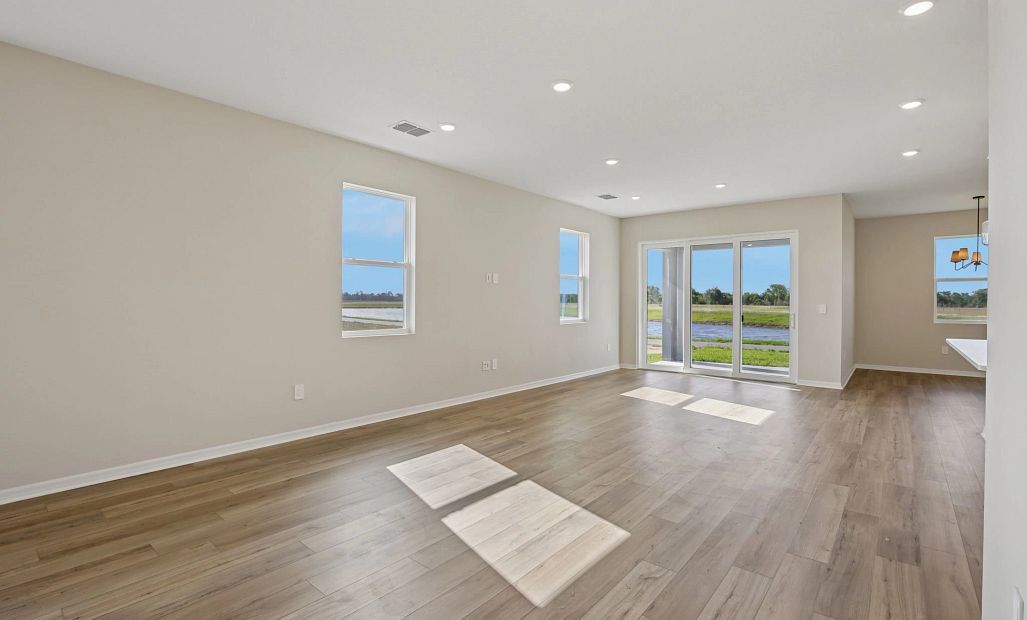 The dining space opens into the family room that looks out through the large sliding glass door at