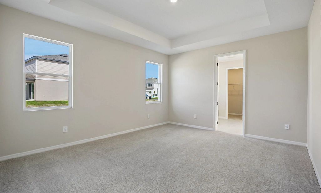 Spacious primary bedroom feature a tray ceiling