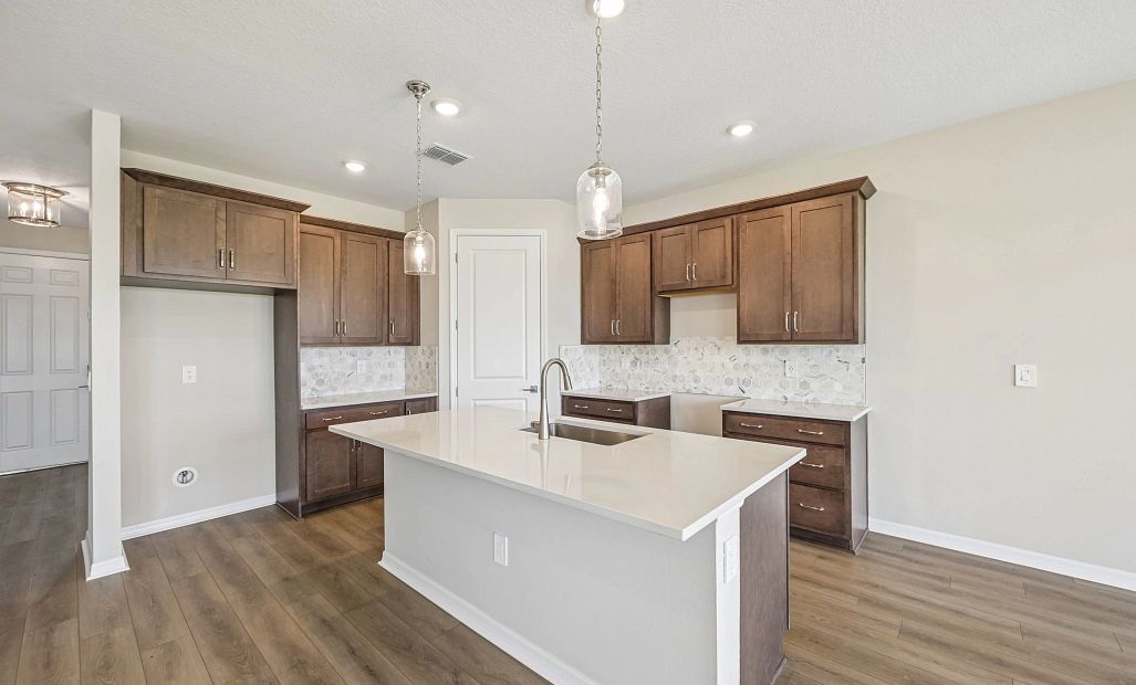 The kitchen features AW Collection® Roosevelt and a large island