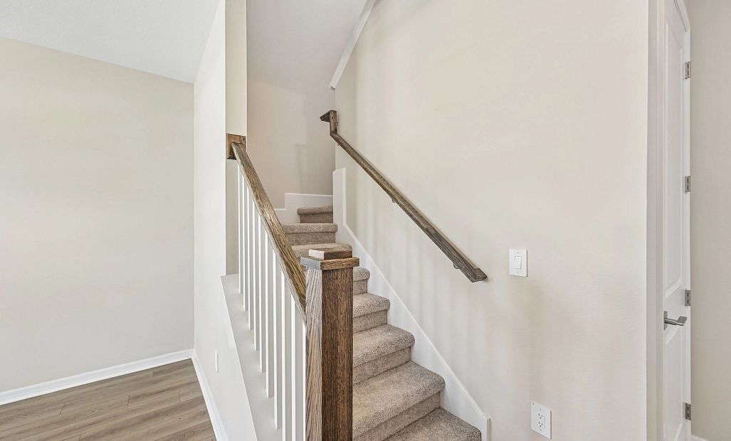 The staircase with the beautiful stained wood railing and spindles will take you up to the rest of