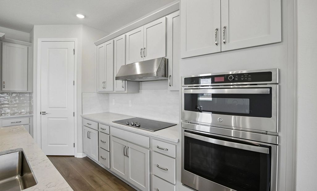 This kitchen is outfitted with a gourmet kitchen featuring a a double stack oven and microwave and a