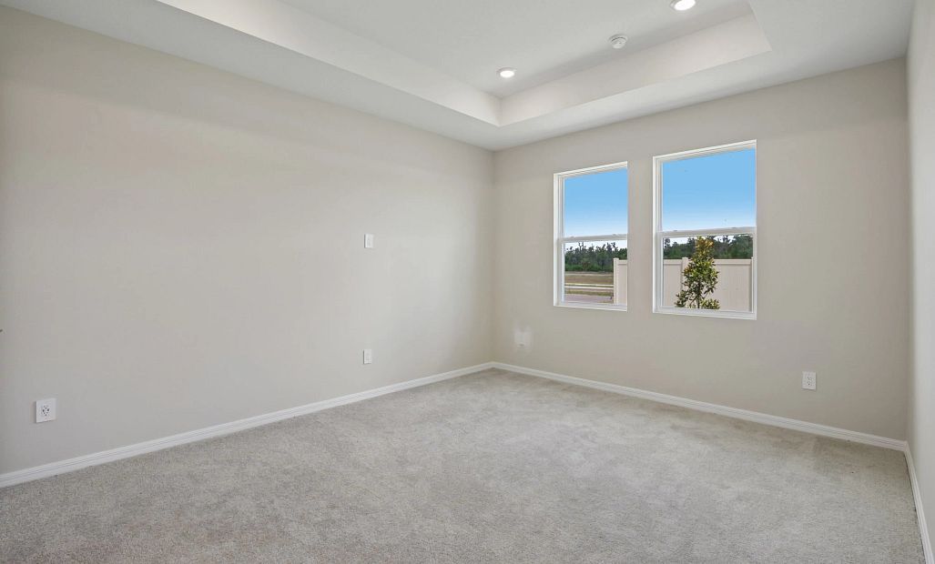 Off the kitchen is the primary bedroom retreat which has a tray ceiling and two windows