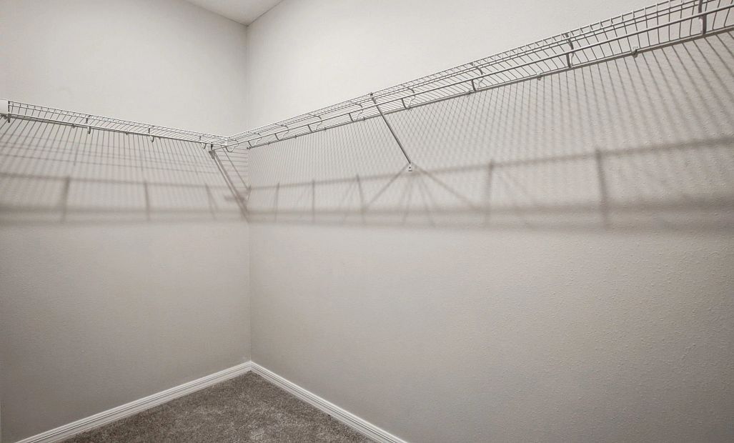 A large walk-in closet is located at the end of the primary bathroom