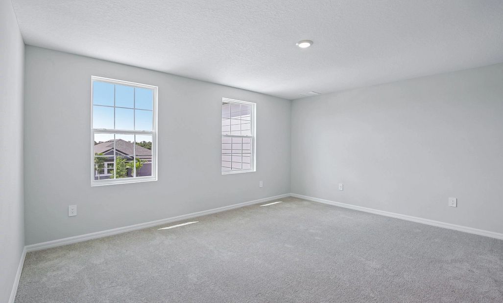 The beautiful primary bedroom features two large windows