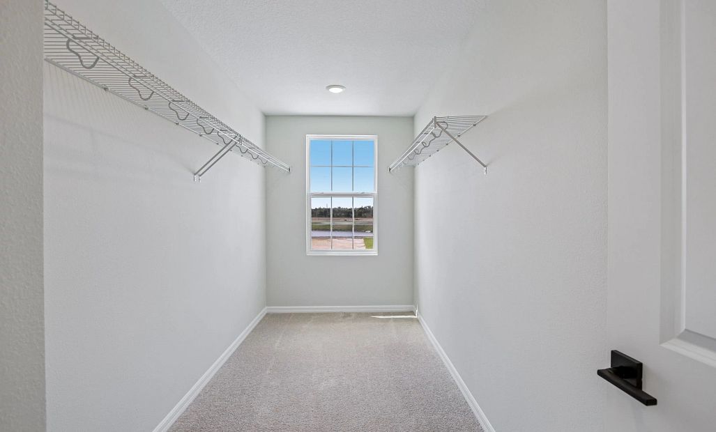 The walk-in closet off the primary bathroom features a window for added natural light