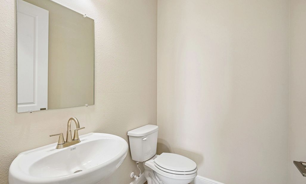 Half bathroom located off the foyer perfect for guests