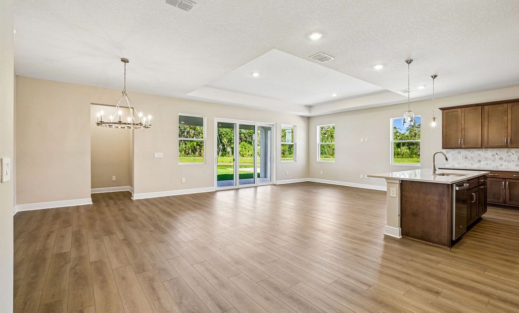 As you continue down the foyer you enter into the open family room, dining room and kitchen space