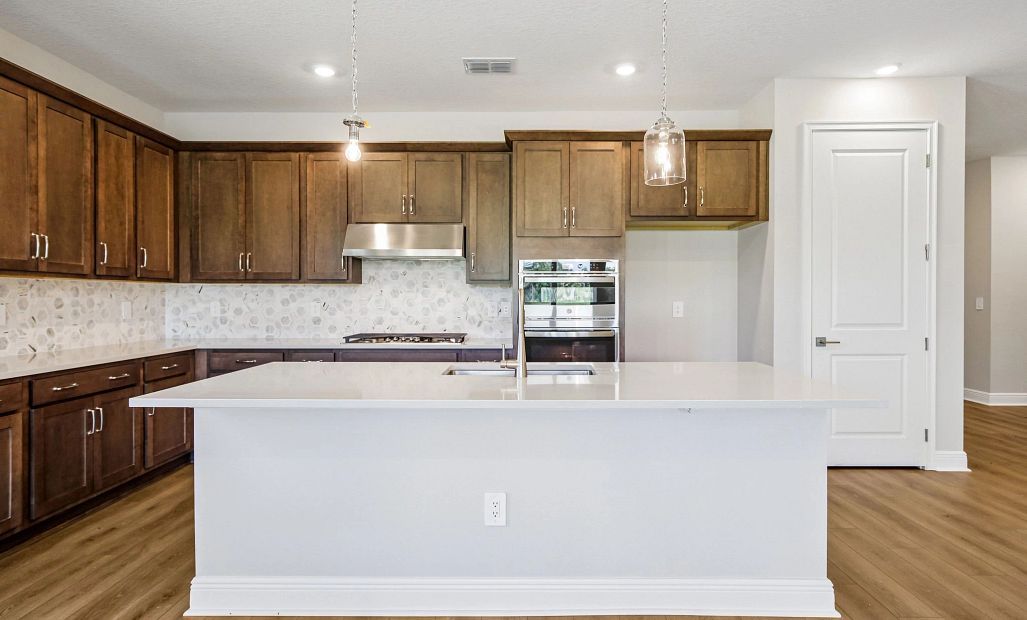 The kitchen features AW Collection® Roosevelt and a large island centers the space