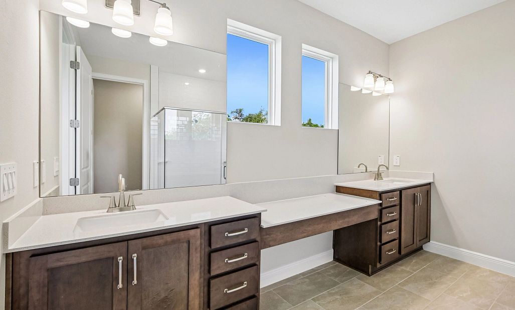 The primary bathroom features aspects of AW Collection® Roosevelt and has separate sinks and two