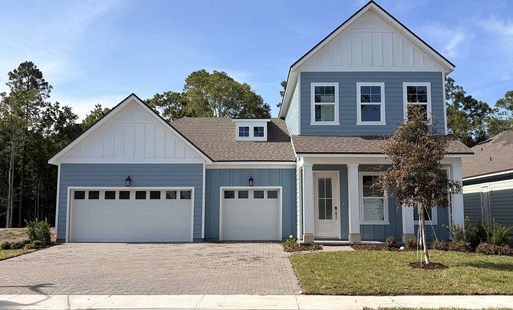 Coral C front elevation featuring a covered front porch and a 3 car garage - under construction