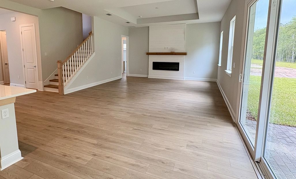 Family room space located off the kitchen with a tray ceiling and stunning fireplace feature - under