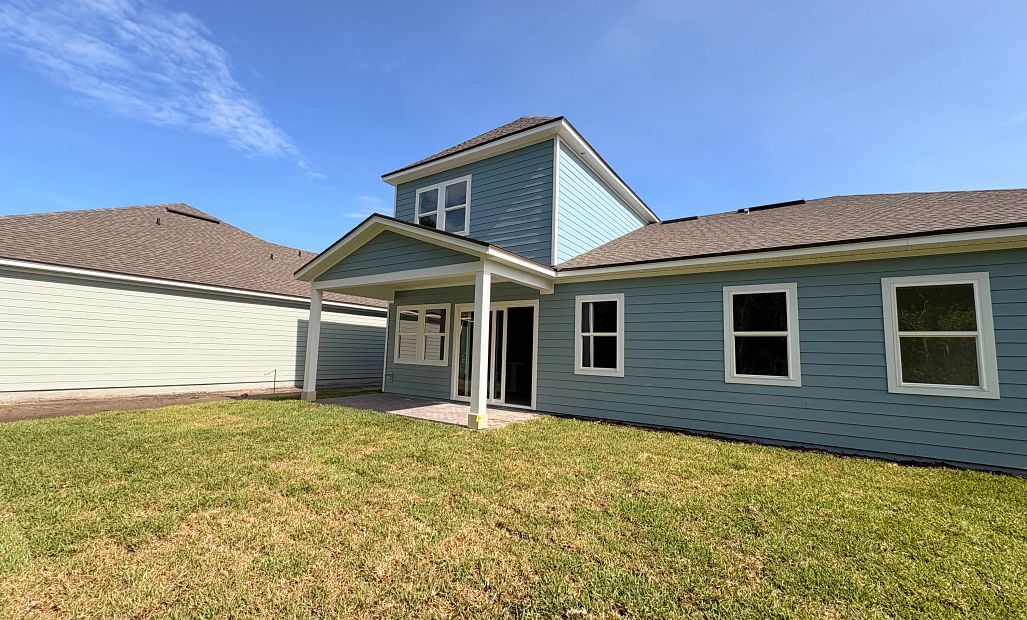 Back of the home with a covered back lanai