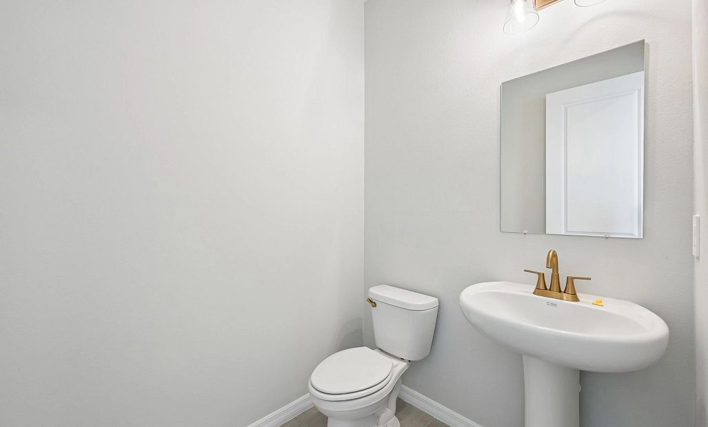 Down the hallway near the dining nook you will find the half bathroom featuring aspects of AW