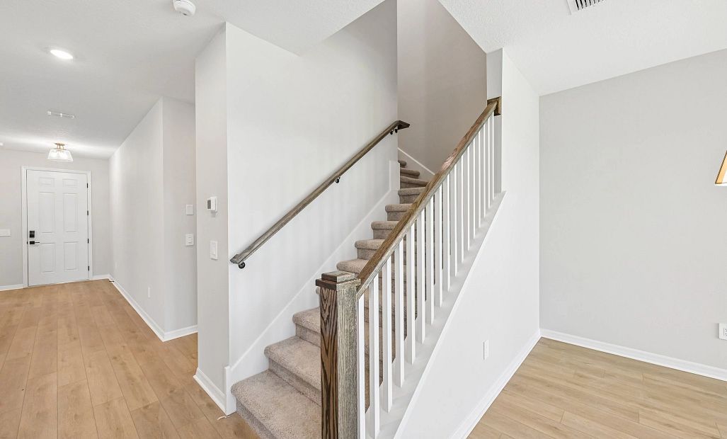 The staircase features an open rail and wooden spindles