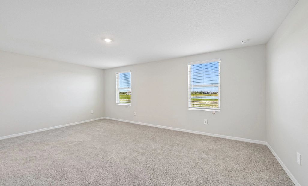 The primary bedroom features two large windows