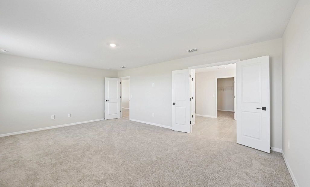 The primary bedroom opens up into the primary bathroom with double doors