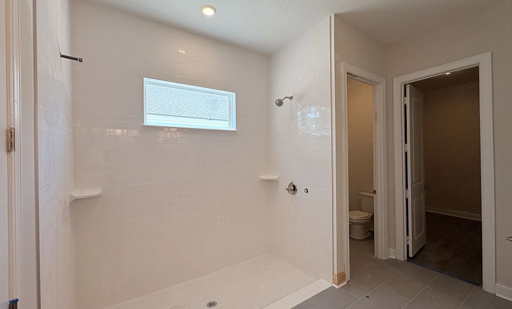 Primary bathroom with an oversized walk-in shower featuring double shower heads - under construction