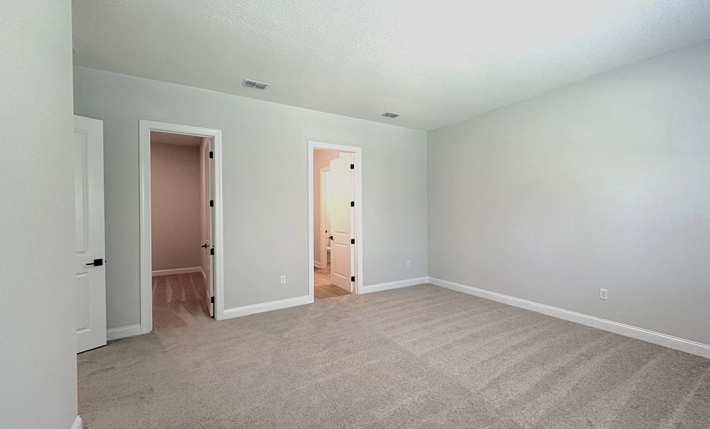 Bedroom 4 featuring a walk-in closet and an attached bathroom