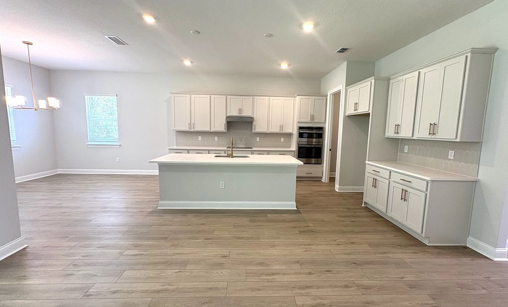 Spacious kitchen featuring AW Collection® Serene, ample cabinets, a stacked microwave and oven