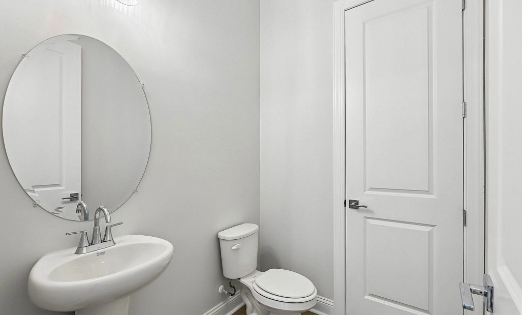 Further down the foyer is the half bathroom perfect for guests and has an extra linen closet