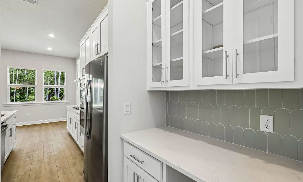 Connecting the dining room and the kitchen is a butler's pantry featuring aspects of AW Collection®